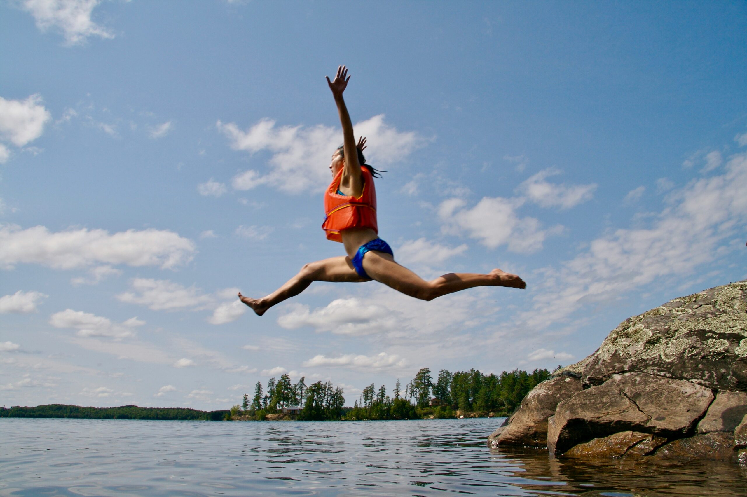 A kid jumping in a lake